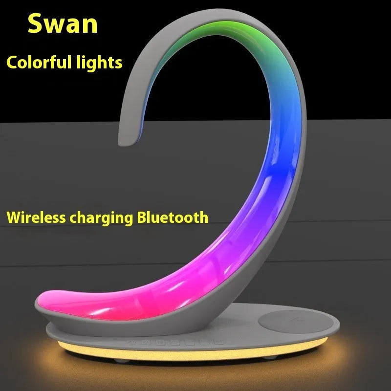 White swan shaped desktop device with colourful lighting, wireless charging pad, and Bluetooth speaker functions