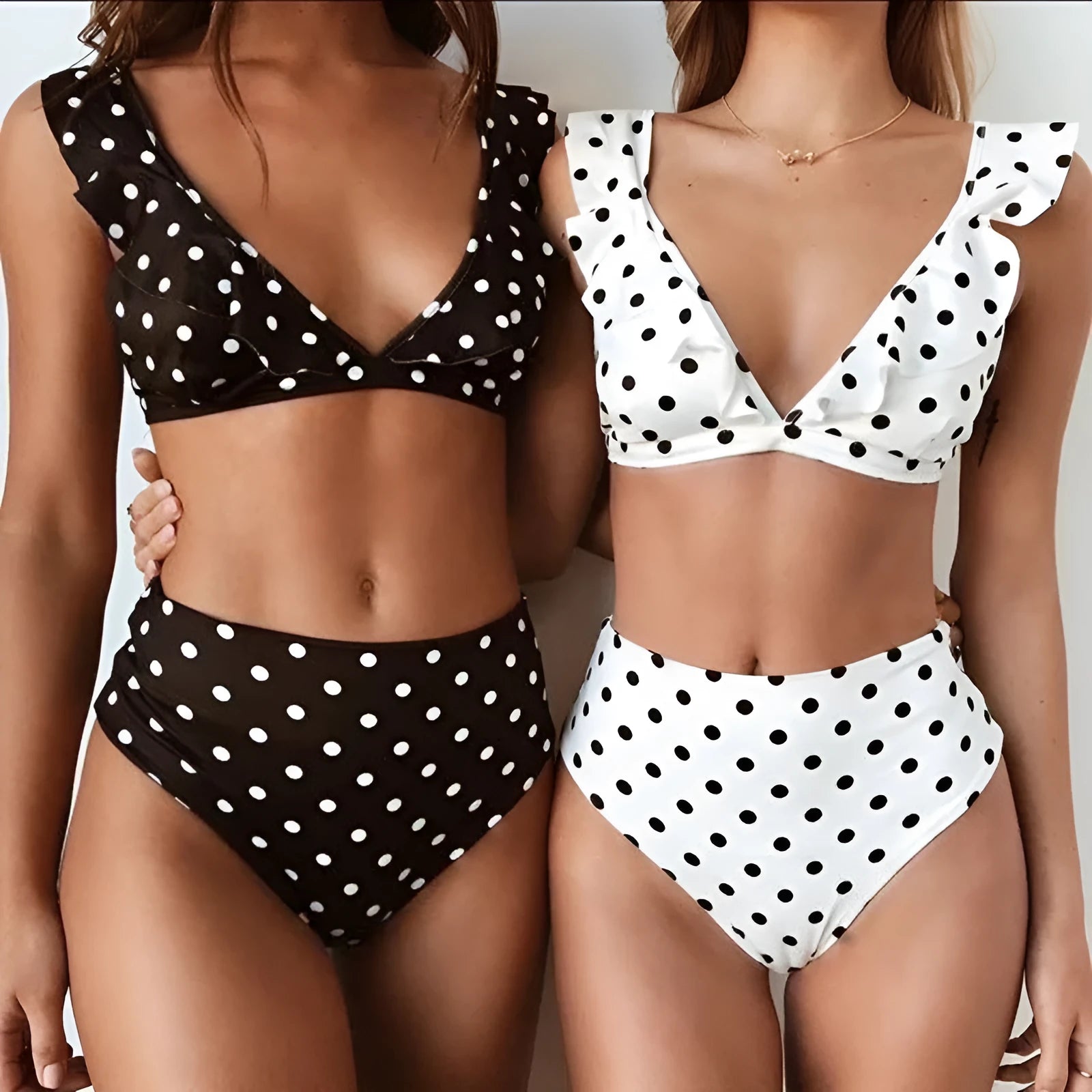 Women's black and white polka dot bikini set with deep V-neck top and ruffles