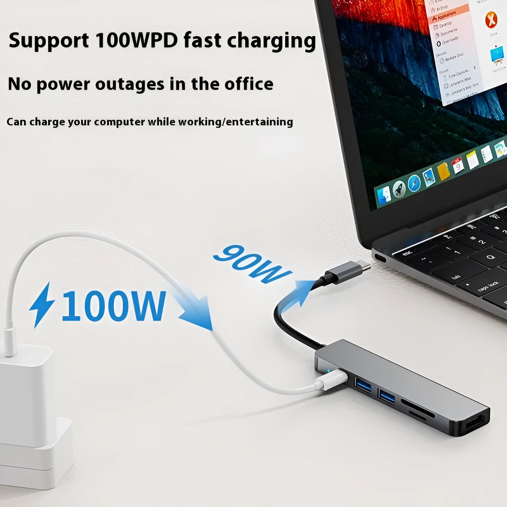 Compact silver USB-C expansion dock for laptops with multiple ports including HDMI and USB-A.