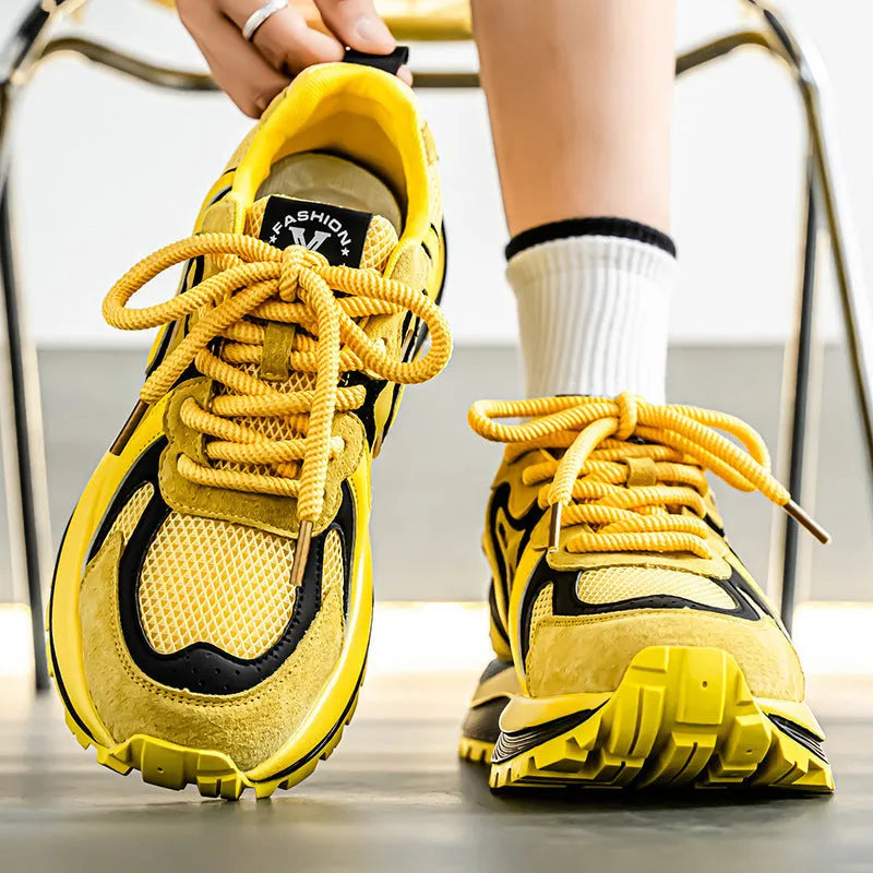 Men's round-toe sneakers in yellow with mesh panels and white laces on a rubber sole.