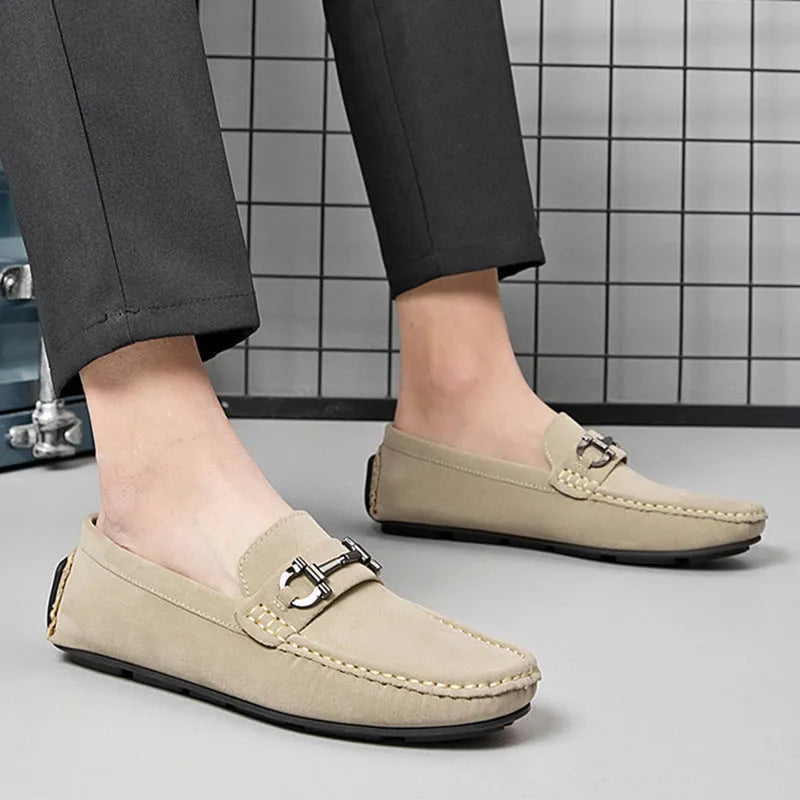 Men's beige slip-on loafers with a round toe and rubber sole on a plain background.