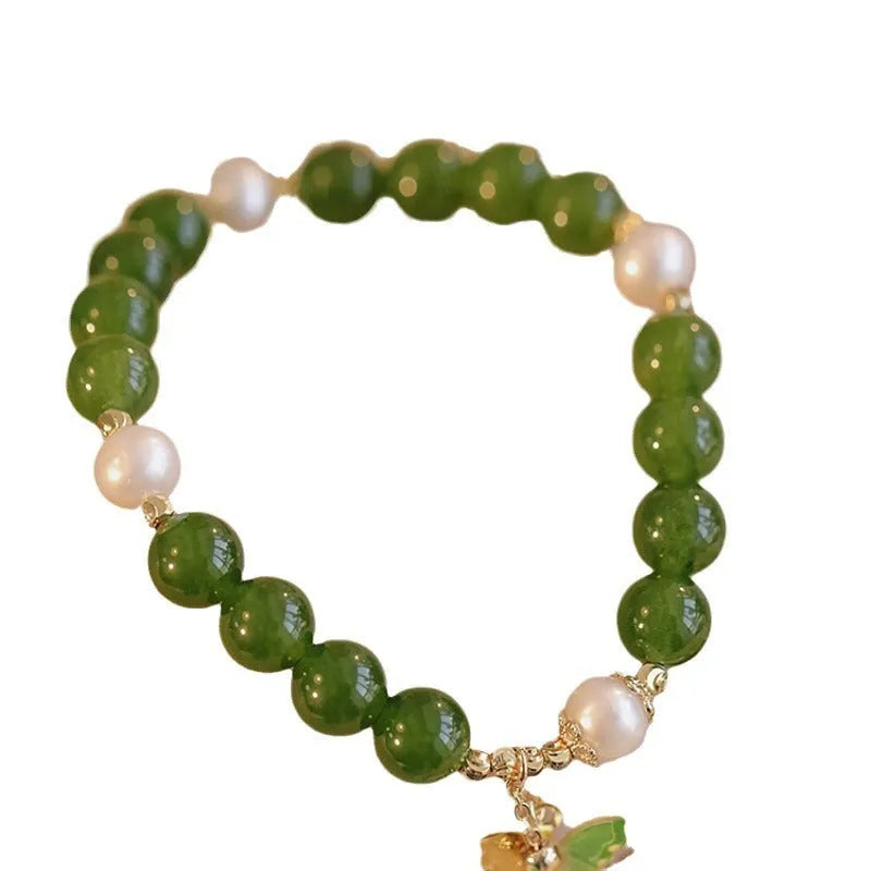 Green chalcedony bracelet with geometric round beads on a wrist.