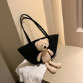 A woven dumpling-shaped shoulder bag in cotton and linen fabric with a three-dimensional front pocket.