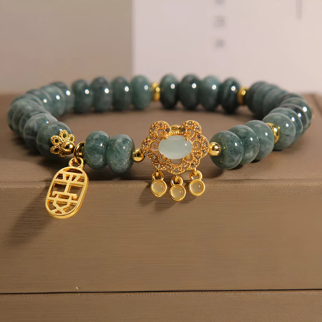 Close-up of a women's bracelet with natural emerald green jade abacus beads and a metallic alloy safety lock clasp.