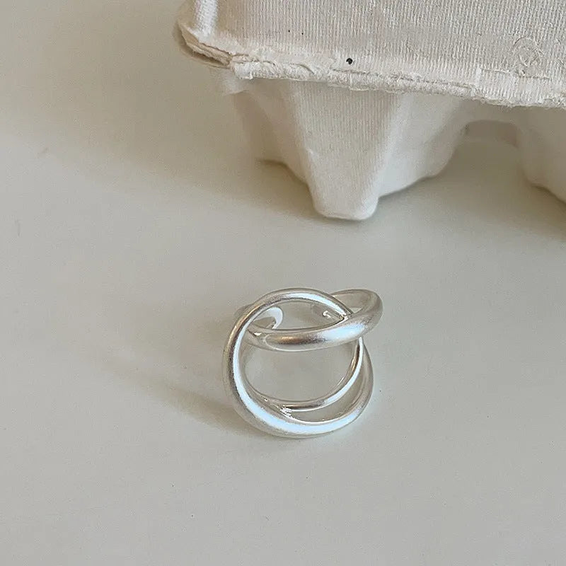 Geometric open ring with interlaced design and matte finish in gold or silver colour with real gold plating