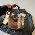 Women's woven straw messenger bag with hollowed design in khaki colour showing vertical square shape and single shoulder strap