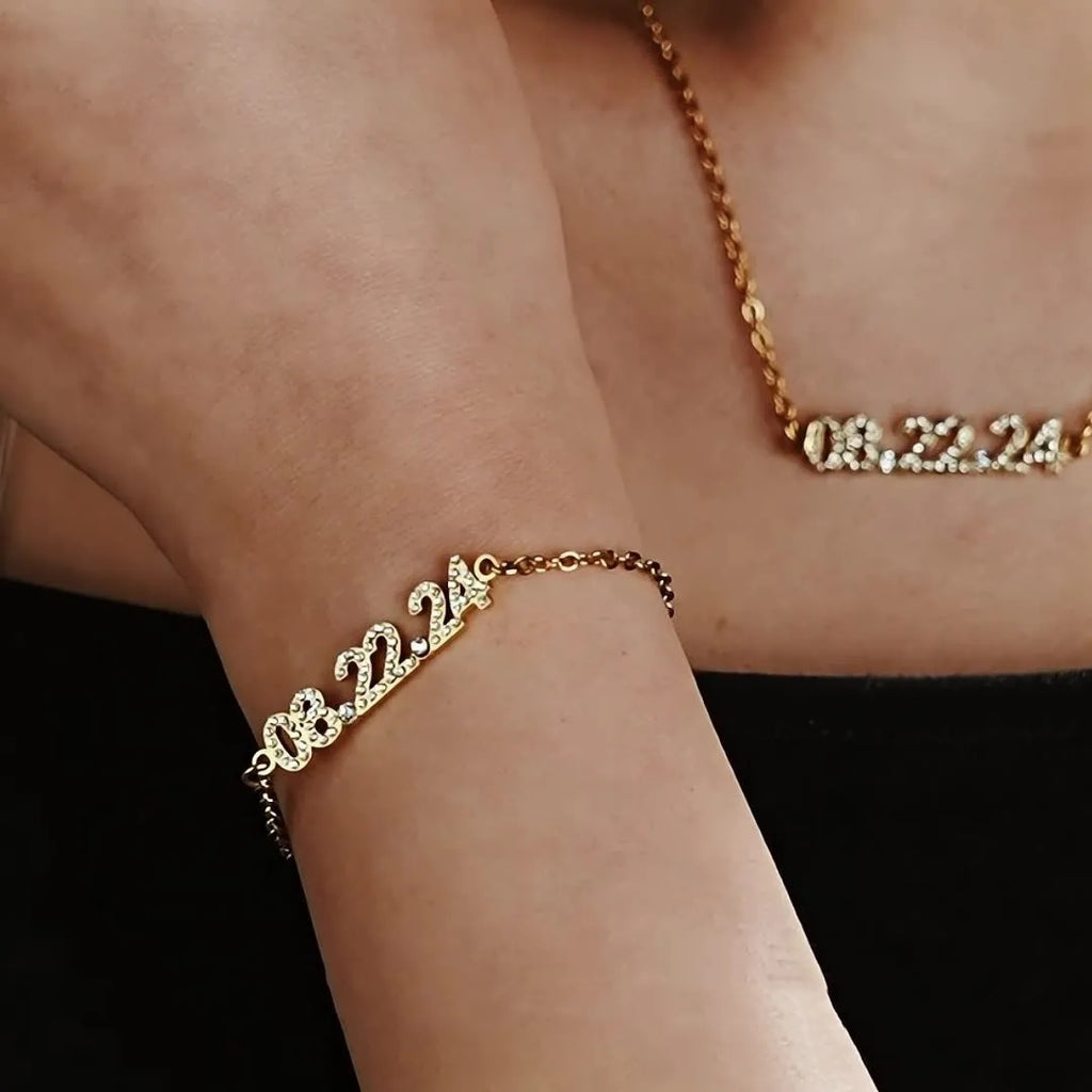Stainless steel digital bracelet with crystal-set bezel showing time display, alongside matching necklace option.