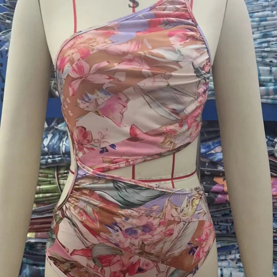 Women's rose gold patterned swimsuit on a hanger.
