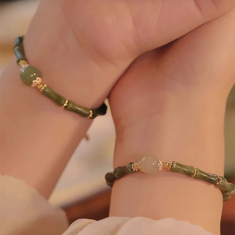 A simple geometric Hetian jade bracelet for women with a Yuan dynasty smoked design, shown in dark green.