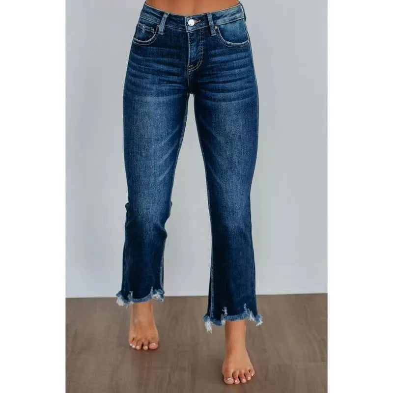 Women's hand-worn denim trousers in dark blue, showing 100% cotton fabric and casual fit