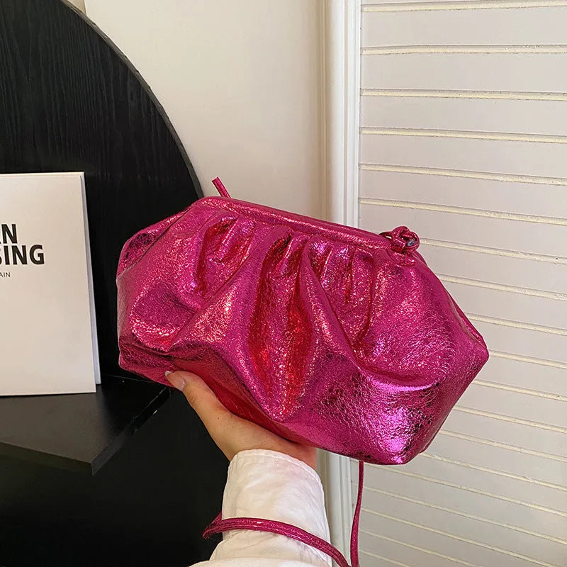 Simple hair clip shoulder crossbody bag in shell shape with sewing line details, shown in rose red colour with zippered compartments.