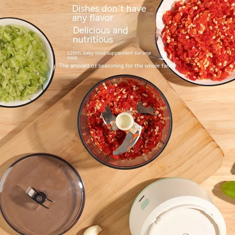 Mini meat grinder with white or light green housing, stainless steel blades, and transparent 225ml cup on anti-slip pad
