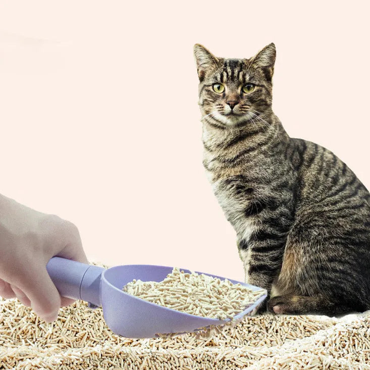White ABS plastic cat litter scoop standing on a matching storage base with integrated waste bag roll.