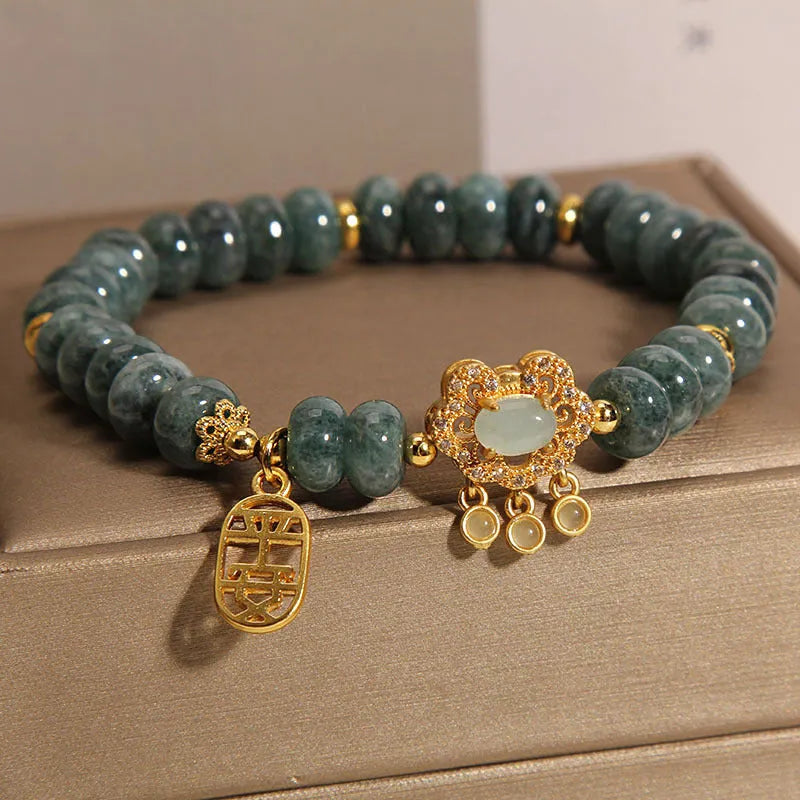 Close-up of a women's bracelet with natural emerald green jade abacus beads and a metallic alloy safety lock clasp.