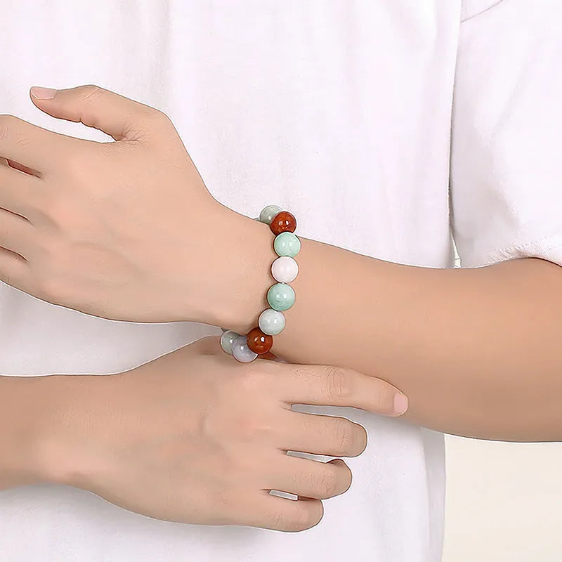 Women's Myanmar jade bracelet with 13mm round beads showing three natural jade colours