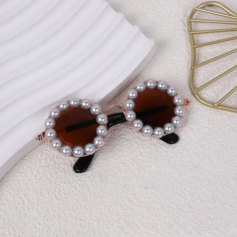 Pearl-rimmed round sunglasses for cats and dogs in black, blue, coffee, orange, and purple.