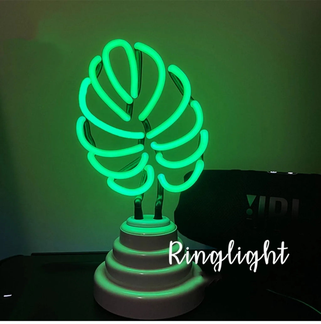 White bamboo-shaped desktop lamp with green light, USB cable, and minimalist design on wooden desk