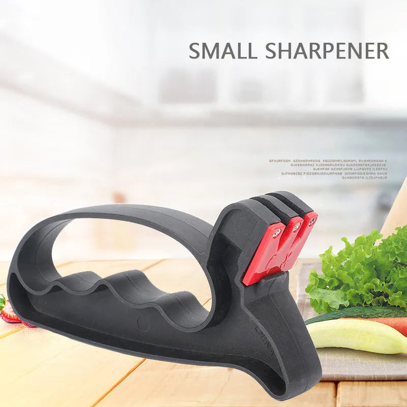 Black handheld tungsten steel knife and scissor sharpener on a kitchen counter