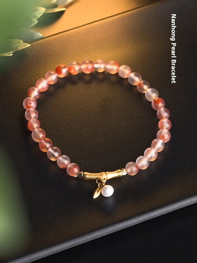 Close-up of a handmade nanhong agate bracelet with a flower design and bamboo joint detail.