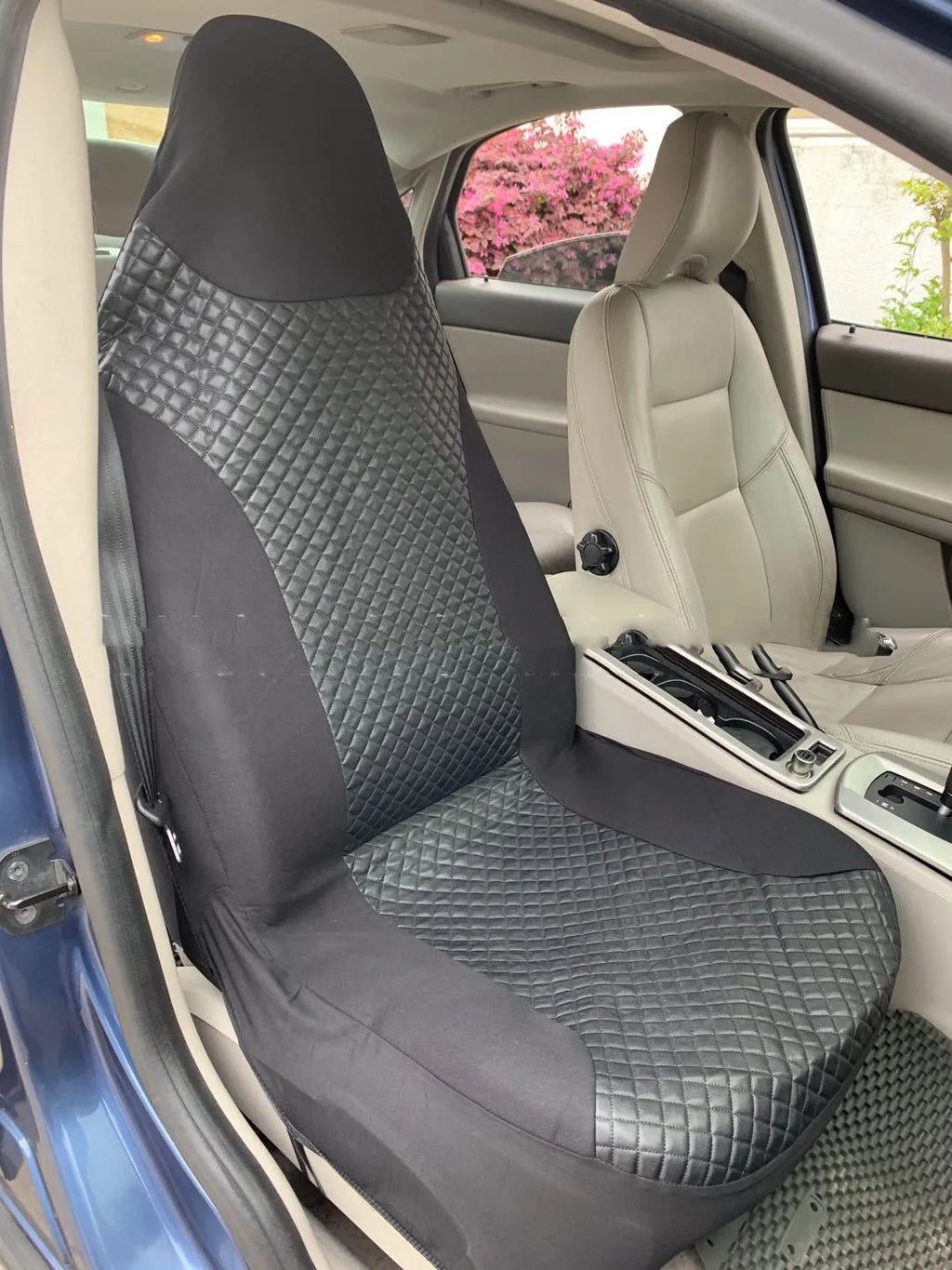 Black quilted automotive seat cover with PU and polyester fabric, showing sponge layer and plastic hooks