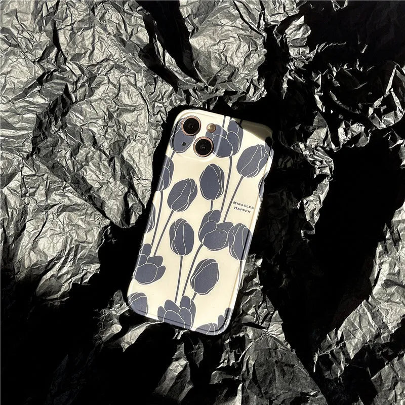 Black silicone iPhone case with a detailed tulip floral pattern on the back.