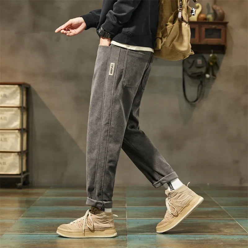 Men's tapered corduroy trousers in army green showing straight-leg street fashion style