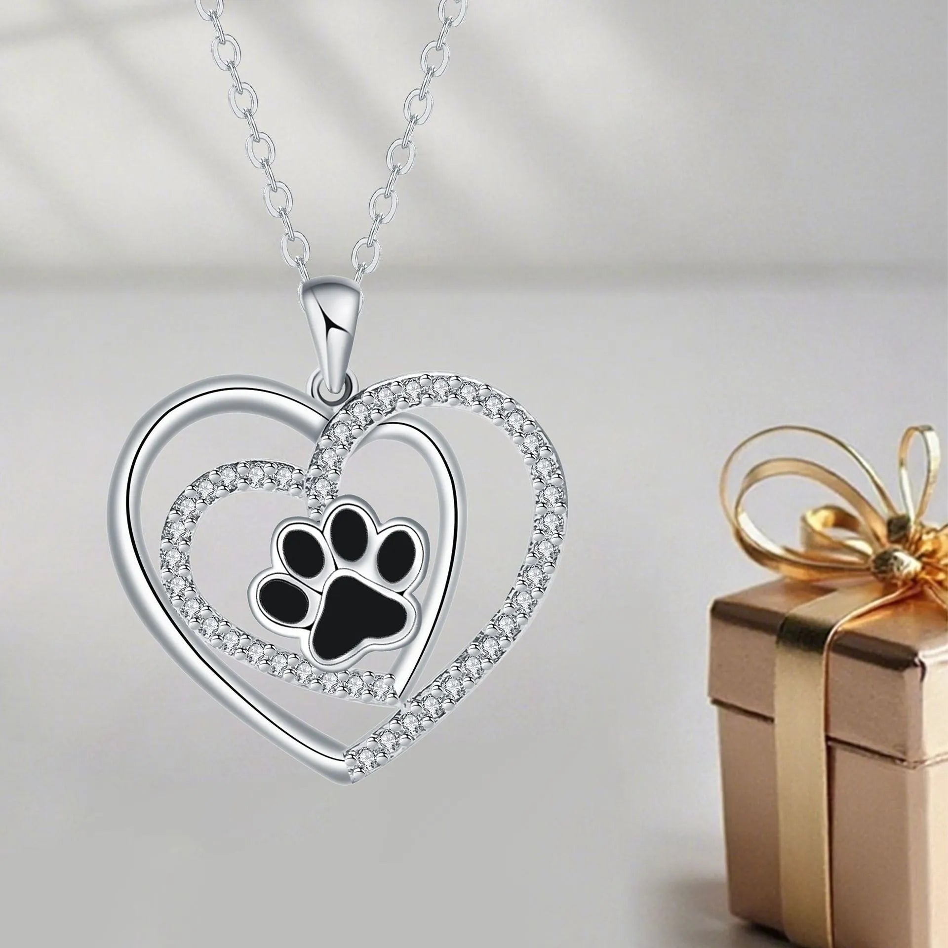 Women's copper necklace with dog paw and heart pendant on a cross chain.