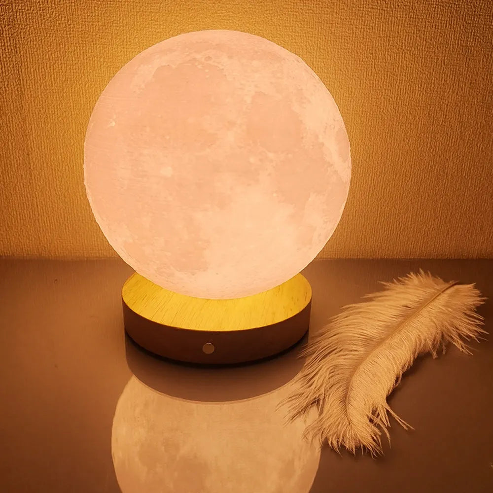 Rotating sleeping moon night lamp on a wooden base, showing three-colour light options.