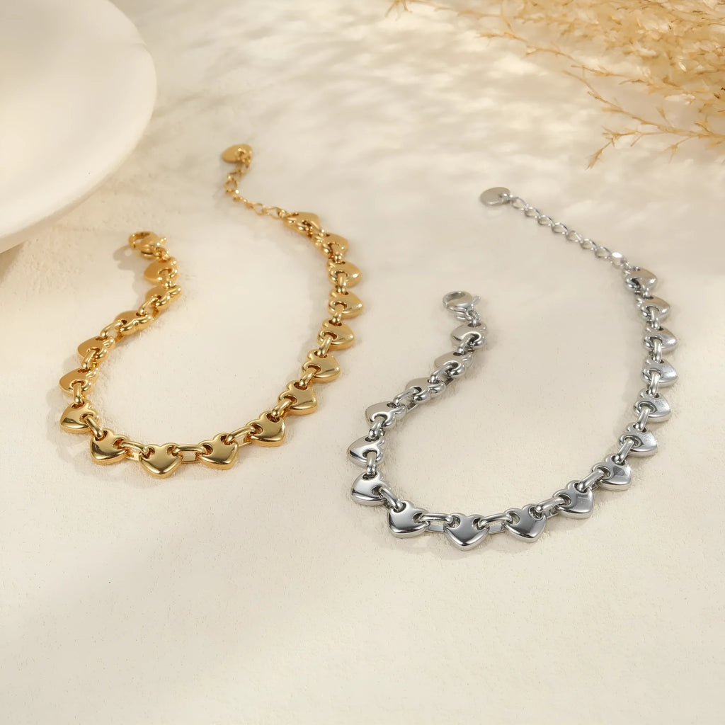 Stainless steel women's bracelet with a hollowed-out heart design in gold, steel, or colour-blocked finish.