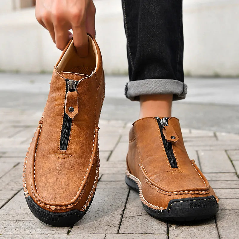 Men's slip-on loafers in black with round toe, low heel, and sewing thread details on PU upper