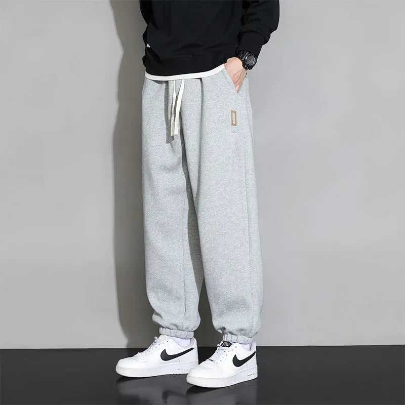 Men's loose grey cotton sports trousers with elastic waistband on hanger