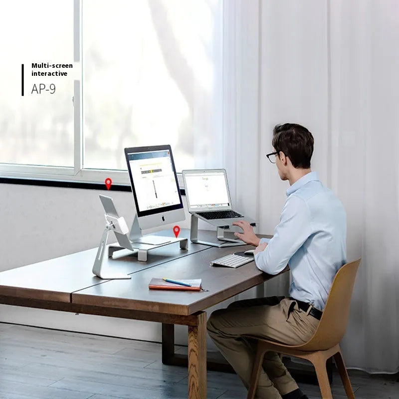 Aluminium alloy laptop stand in black or silver on a desk, showing its raised platform design.
