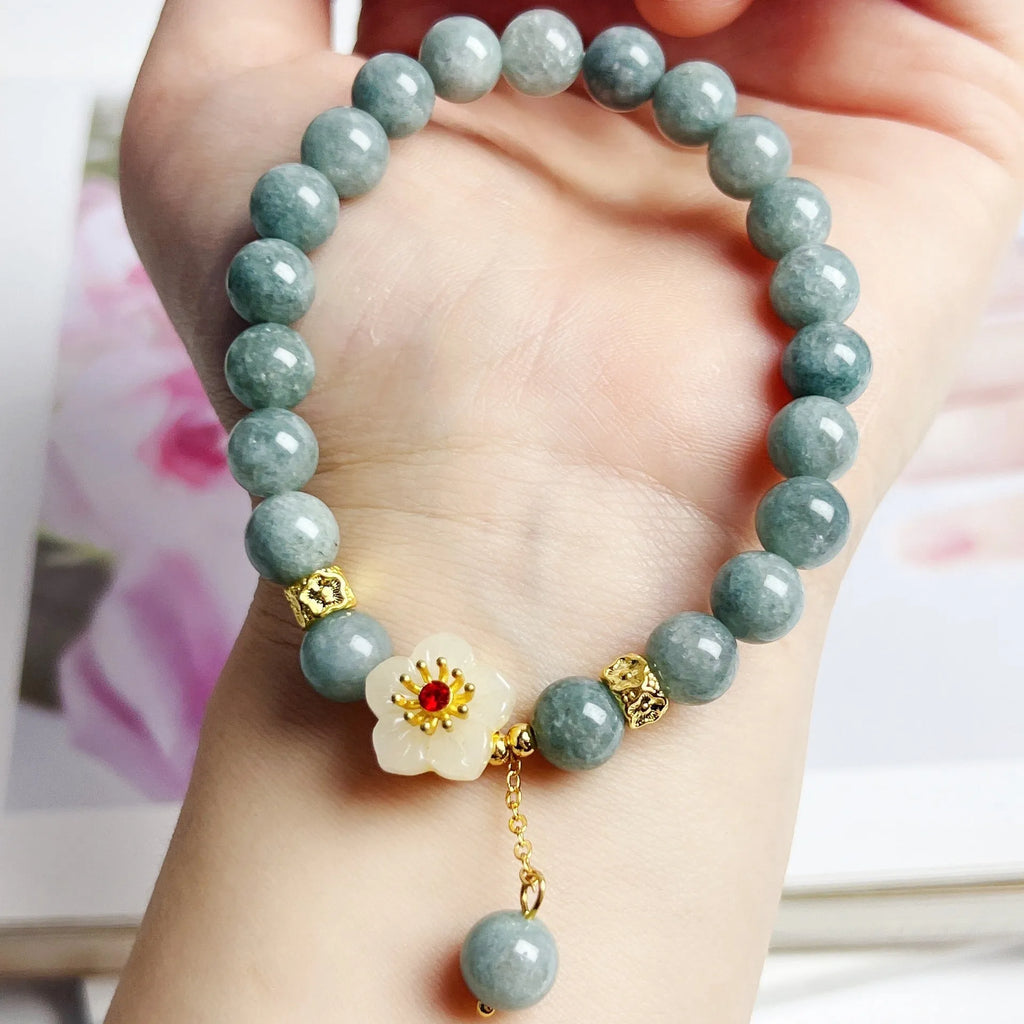 Handmade green jade bracelet with adjustable cotton cord fastening on a wrist.