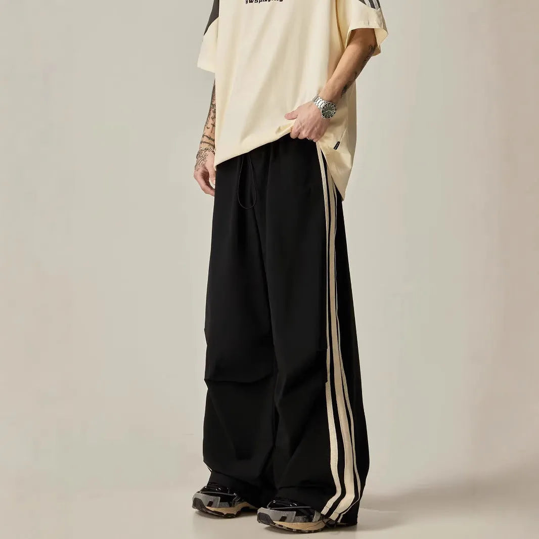 Men's black wide leg climbing pants with high waist and straight-leg design on hanger