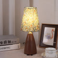 Nordic retro ceramic bedside table lamp with a pleated tapered floral fabric shade on a ceramic base.