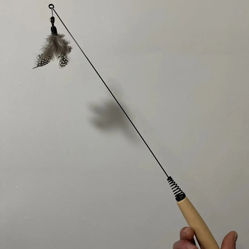 Cat teasing stick with wooden handle, flexible metal spring, and feather bell replacement head