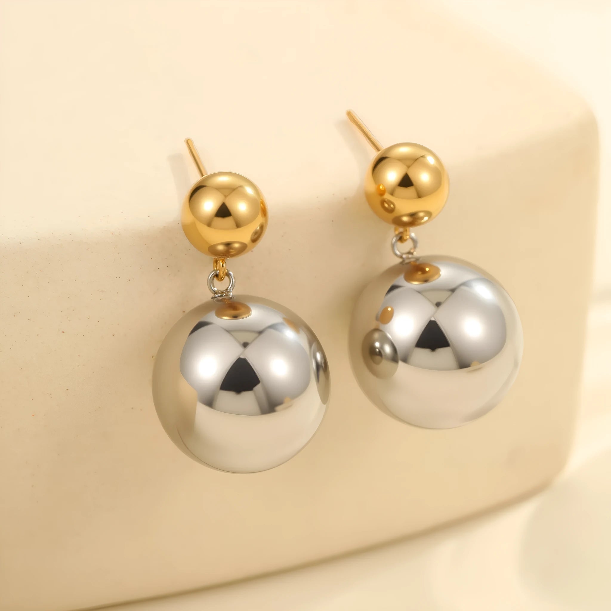A pair of women's stud earrings with colour-blocked round geometric beads on stainless steel posts.