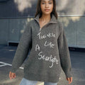 Woman wearing a light khaki alpaca wool pullover sweater with loose lapels, a turtleneck, and an oblique zipper.