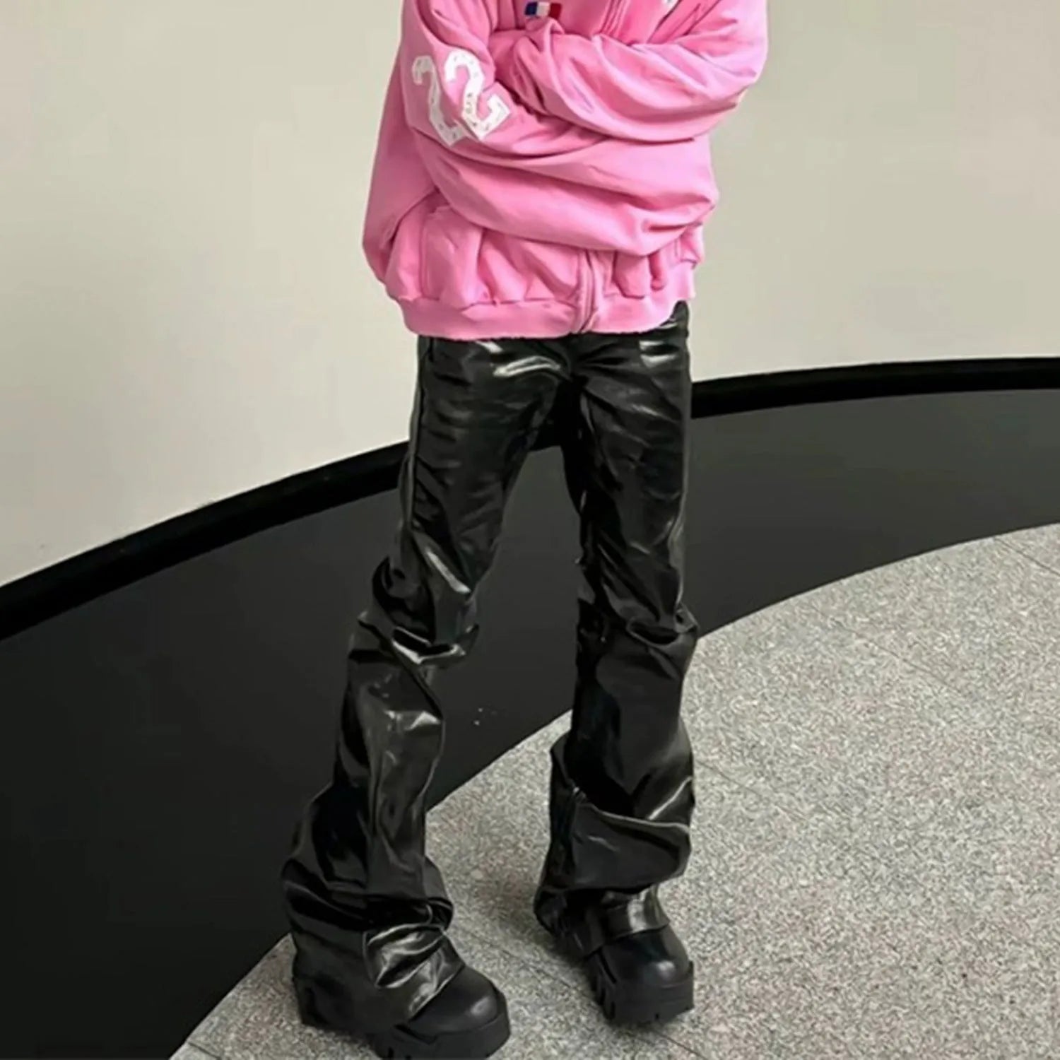 Black coated shiny patent leather skinny jeans with mid-waist straight-leg cut on a model