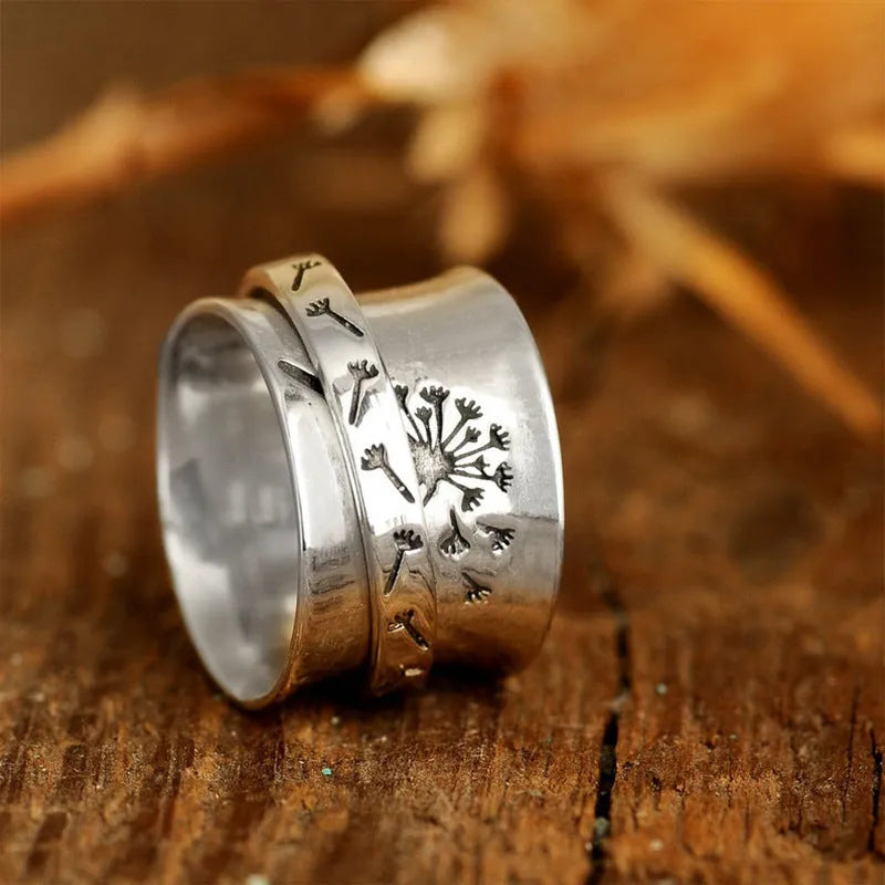 Silver flower ring on a finger showing its rotatable band and adjustable open design.