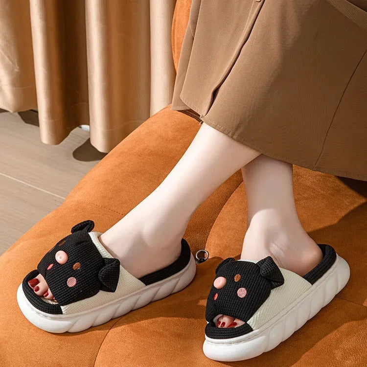Pair of piggy cute open toe linen flip flop slippers for couples on a plain background.
