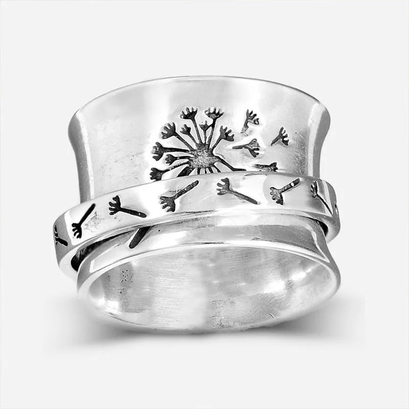 Silver flower ring on a finger showing its rotatable band and adjustable open design.