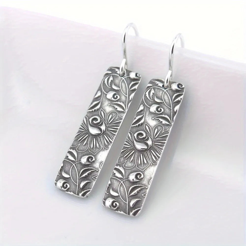 Silver geometric long earrings with carved vine detailing measuring 20 cm