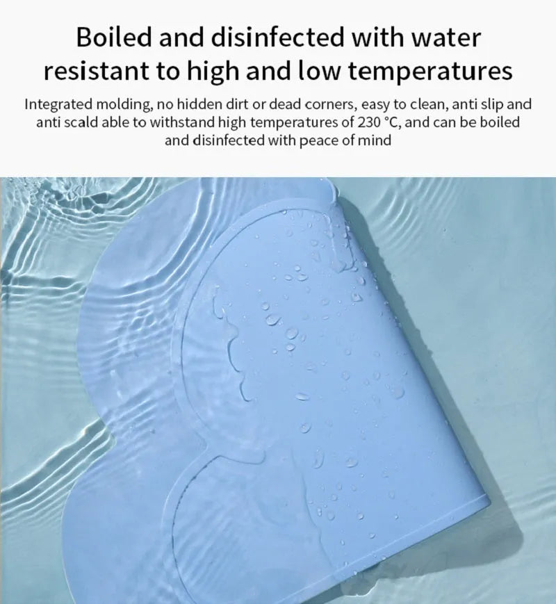 Blue cat head shaped silicone pet feeding mat placed under food and water bowls.