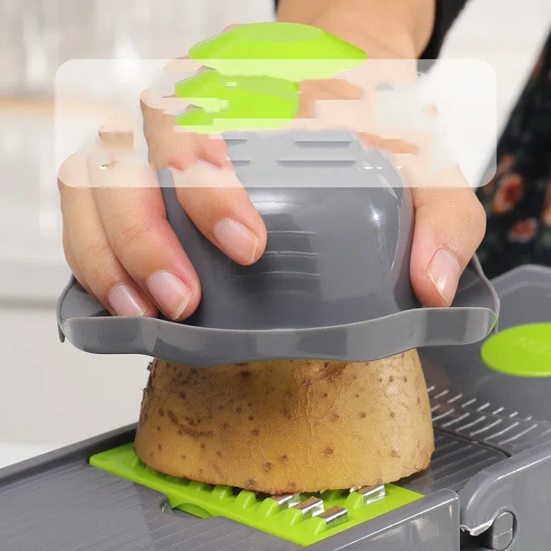Grey stainless steel vegetable cutter with interchangeable blades and kitchen accessories