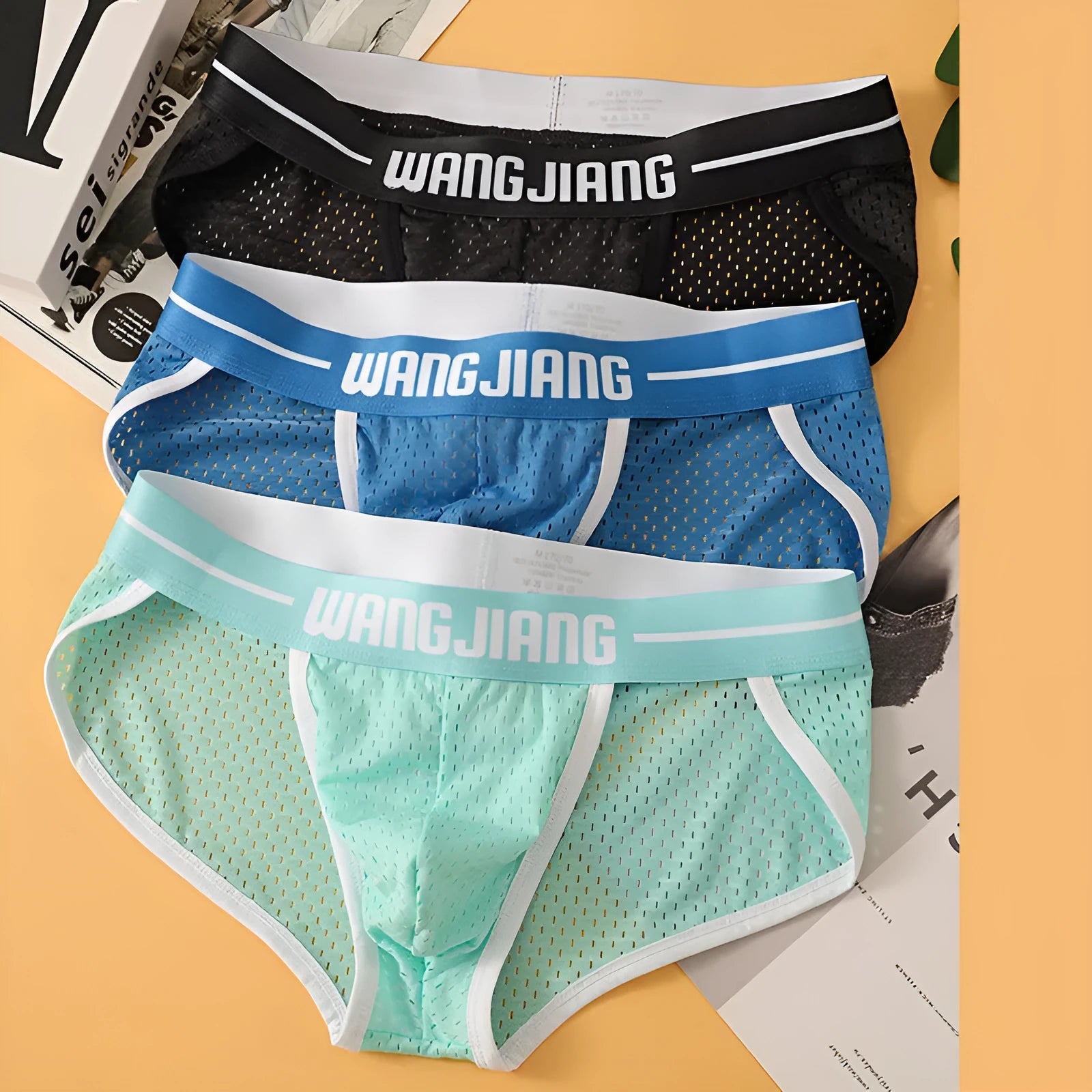 Men's black mesh ice silk triangular underwear laid flat, showing briefs style and breathable fabric texture.