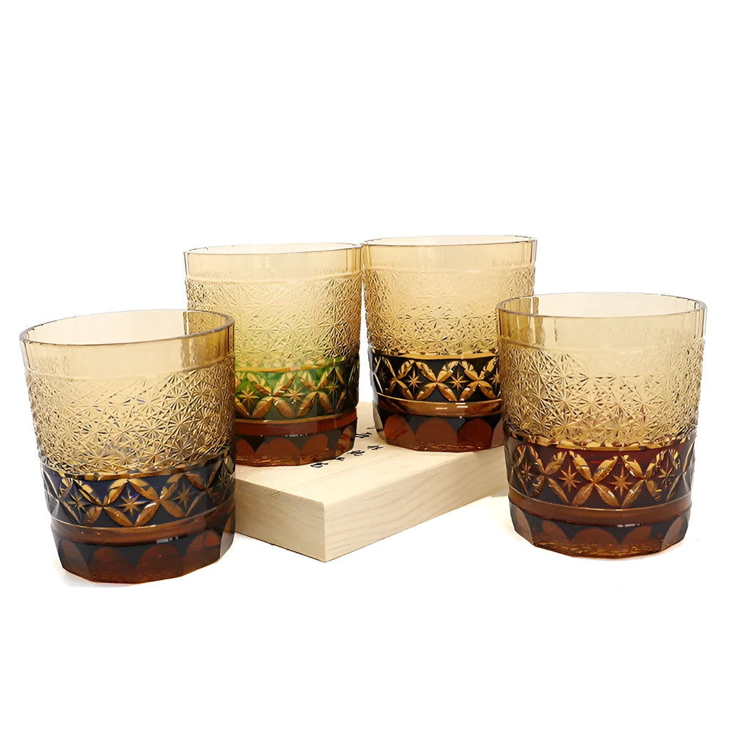 Hand carved Japanese style crystal whiskey glass in amber colour on a dark surface