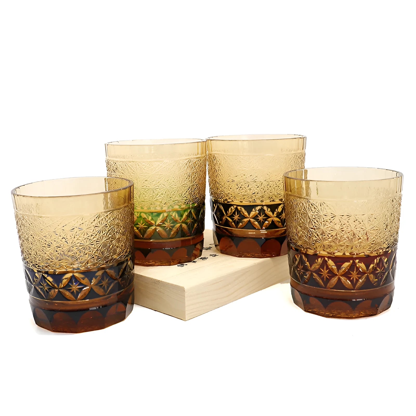 Hand carved Japanese style crystal whiskey glass in amber colour on a dark surface