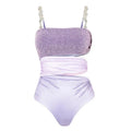 Purple one-piece swimsuit with high-cut legs and a matching wrap skirt laid flat.