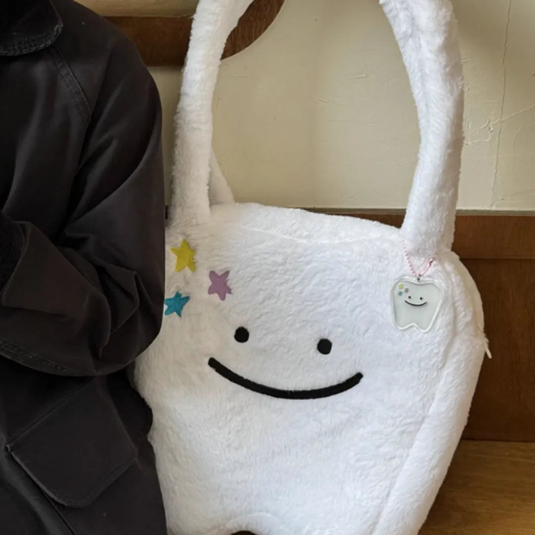 White plush tote bag with cute tooth graphic and a crossbody strap.